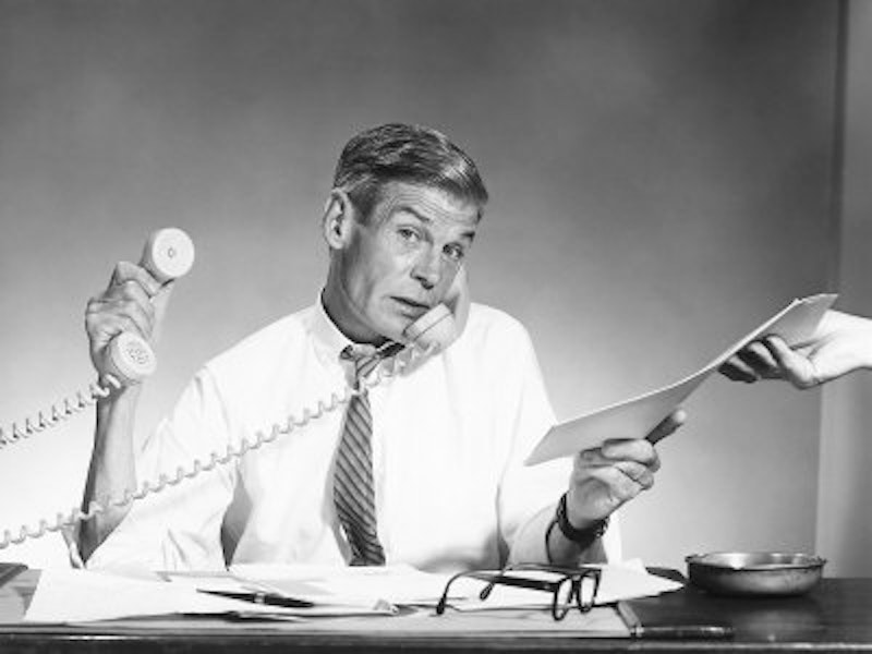 Man working hard with two telephones.jpg?ixlib=rails 2.1