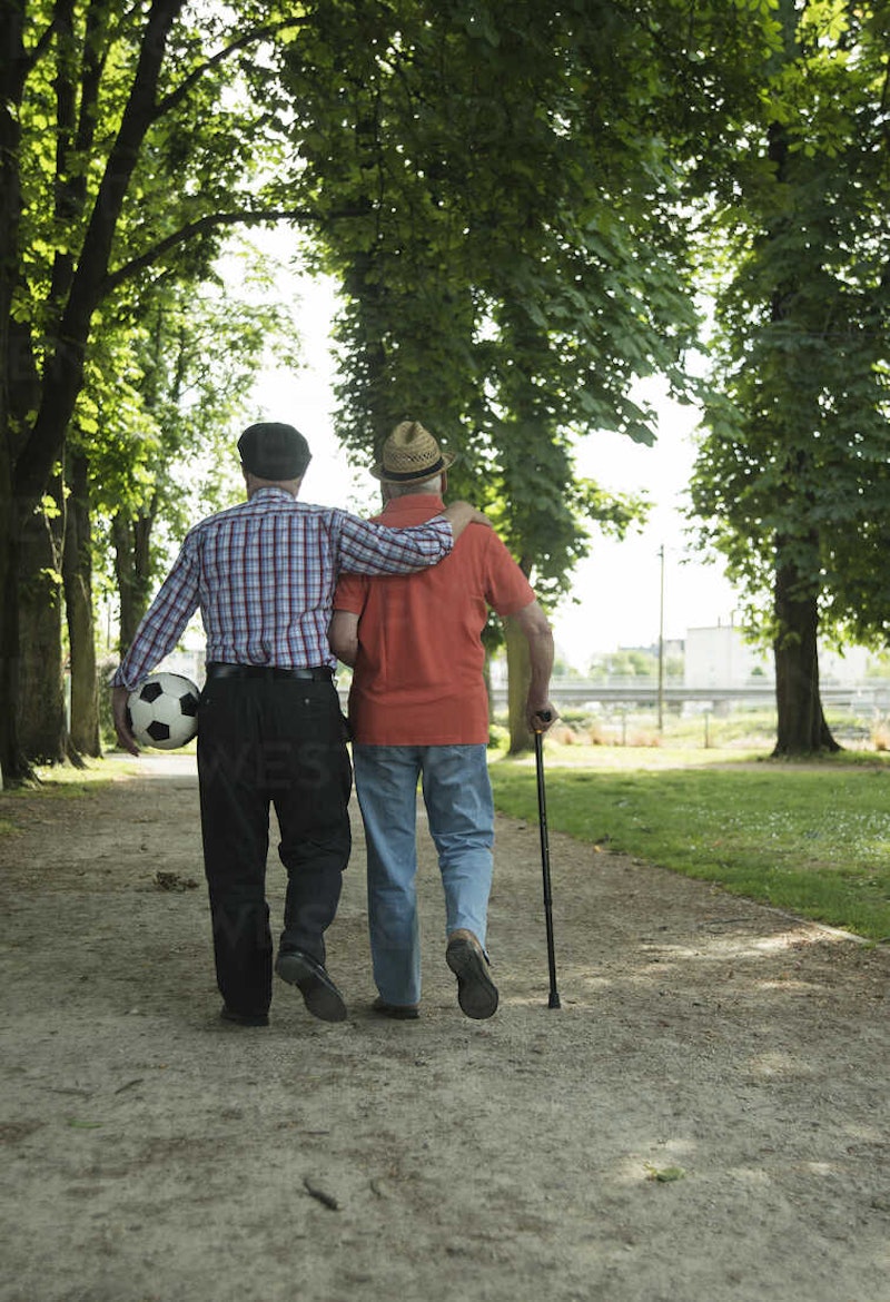 Two old friends walking in the park with football back view uuf000714.jpg?ixlib=rails 2.1