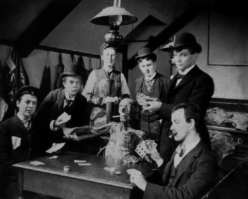 Medical students playing cards with cadaver propped up with a lit cigarette in its mouth.png?ixlib=rails 2.1