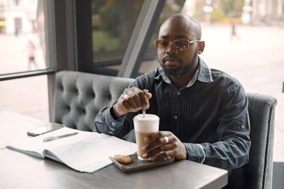 Black man sitting coffee shop drinking latte man wearing sunglasses grey shirt 1157 50791.jpg?ixlib=rails 2.1
